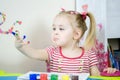 Little cute girl paints with fingers