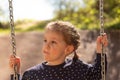 Little cute girl with pigtails smiling rides on a swing in polka dot clothes