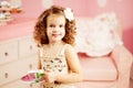 Little cute girl in a pink dress drinks tea with sweets in the c Royalty Free Stock Photo