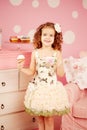 Little cute girl in a pink dress drinks tea with sweets in the c Royalty Free Stock Photo
