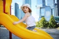 Little cute girl at plastic slide at playground