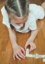 Little cute girl playing dominoes. Royalty Free Stock Photo