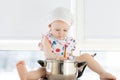 Little cute girl playing in kitchen with pots