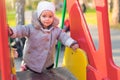 Little cute girl playing at the playground in autumn