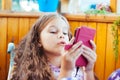 little cute girl playing with a smartphone, daylight, at home Royalty Free Stock Photo
