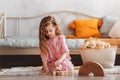 A little girl plays with wooden cubes on the floor in the children`s room Royalty Free Stock Photo