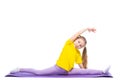 Little cute girl is practicing stretching on a gymnastic mat. Isolated on white background. Royalty Free Stock Photo