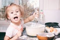 A little cute girl preparing the dough in the kitchen at home