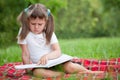 Little cute girl preschooler with book in park