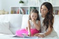 Little cute girl reading book with mother while sitting on safe Royalty Free Stock Photo