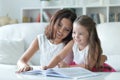 Little cute girl reading book with mother at the table Royalty Free Stock Photo