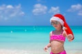 Little cute girl in red Santa hat on tropical Royalty Free Stock Photo