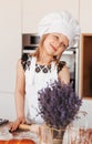 A little cute girl with a rolling pin for dough in the kitchen. The child cooks buns. Children cook food Royalty Free Stock Photo