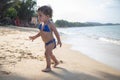 little cute girl is running and playing on a beach near the sea on vacations. Royalty Free Stock Photo