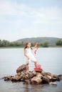 Little cute girl and scarlet sails. Girl sitting on the rocks on the seashore ocean with the ship. Summer day. Happy childhood c Royalty Free Stock Photo