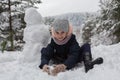 Little cute girl sculpts snowman. Game.