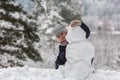 Little happy girl sculpts snowman in the winter Park. Royalty Free Stock Photo