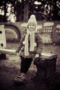 Little cute girl sitting on the bench in winter time. Monochrome Royalty Free Stock Photo