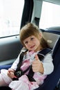 Little cute girl sitting in the car in child safety seat Royalty Free Stock Photo