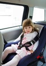 Little cute girl sitting in the car in child safety seat Royalty Free Stock Photo