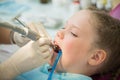 Little cute girl sitting in chair at dentist clinic during dental checkup and treatment, closeup portrait. Royalty Free Stock Photo