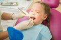 Little cute girl sitting in chair at dentist clinic during dental checkup and treatment, closeup portrait. Royalty Free Stock Photo