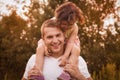 Little girl is sitting on her father`s shoulders in the summer in the park Royalty Free Stock Photo