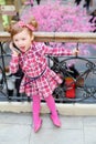 Little cute girl stands near wrought railings and shouts to mobile