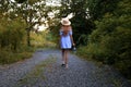 Little cute girl in a straw hat. Evening forest walk with an ancient lantern in his hands. Summer, sunlight, portrait Royalty Free Stock Photo