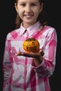 Little cute girl with tangerine posing in the studio on a black background Royalty Free Stock Photo