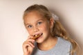 Little cute girl tastes cookies, toothless mouth,