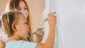 Little cute girl with teacher writing on the blackboard in classroom Royalty Free Stock Photo