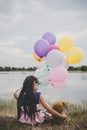 Little cute girl with teddy bear sitting on long green grass out Royalty Free Stock Photo