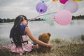 Little cute girl with teddy bear sitting on long green grass out Royalty Free Stock Photo