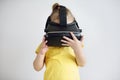 A little girl with virtual reality glasses. A child wearing virtual reality goggles watching movies or playing video