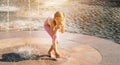 Little cute girl walking in open street fountain at hot sunny day Royalty Free Stock Photo