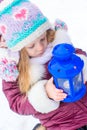 Little cute girl warms her hands on candle in blue Royalty Free Stock Photo