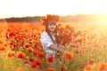 Little cute girl in white dress posing in wreath on her head with a bouquet of poppies in her hands Royalty Free Stock Photo