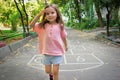 Little cute girl 4 y.o. playing hopscotch on playground outdoors