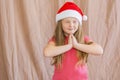 Little girl in santa claus hat dreaming about gifts for new year and christmas copy space Royalty Free Stock Photo