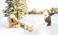 Little cute girls in beige hat,orange scarf snood lying,playing in white snow. Kid walking in beautiful frozen forest Royalty Free Stock Photo