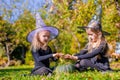 Little cute girls casting a spell on Halloween in