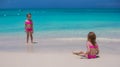 Little cute girls walking on white beach during