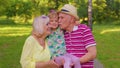 Little cute granddaughter child embracing with her grandmother and grandfather family couple in park Royalty Free Stock Photo