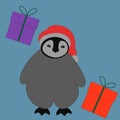 a little cute gray penguin is standing in a red christmas hat with two red and pink gifts on a blue background Royalty Free Stock Photo