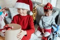 Little cute happy boy in red Christmas santa claus hat with gift in hands from family, parents.Playing kids, congratulations, Royalty Free Stock Photo