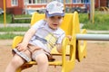 Little cute happy boy rides on carousel on playground