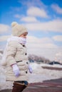 Little cute happy girl is walking in the snow on a