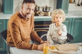 Little cute helpful son whipping eggs with his father