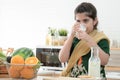 Little cute Indian kid girl holding and drinking a glass of milk for breakfast with crackers and fruits in kitchen at home Royalty Free Stock Photo